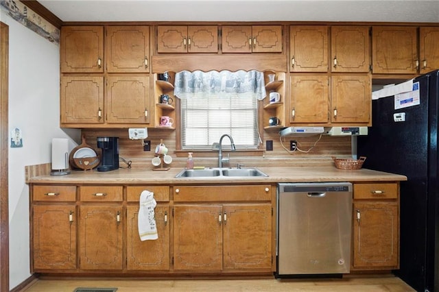 kitchen featuring sink, stainless steel dishwasher, and black fridge