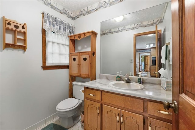 bathroom with vanity, a textured ceiling, tile patterned floors, and toilet