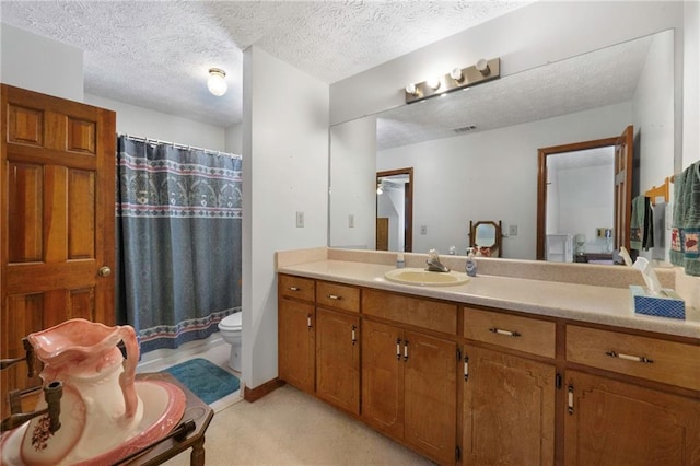 bathroom featuring vanity, toilet, curtained shower, and a textured ceiling