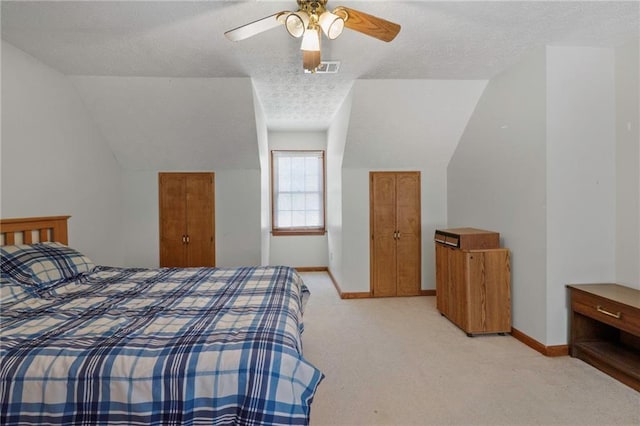 carpeted bedroom featuring ceiling fan, vaulted ceiling, and a textured ceiling