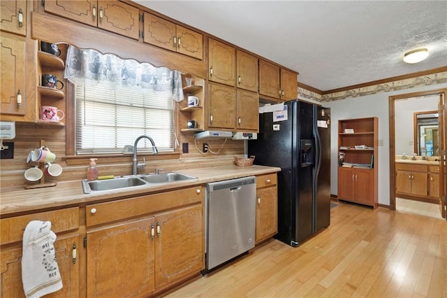 kitchen featuring dishwasher, sink, black fridge with ice dispenser, and light hardwood / wood-style floors