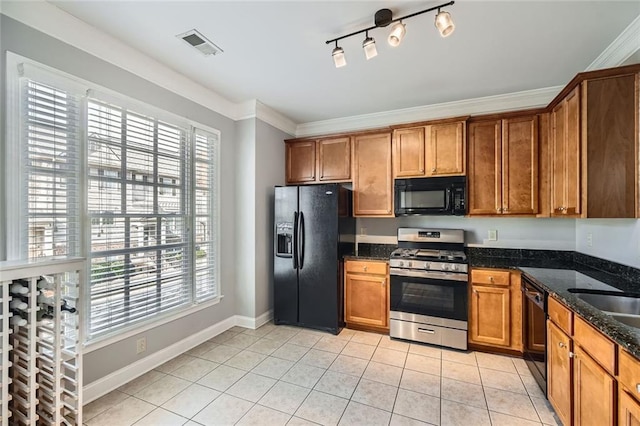 kitchen with black appliances, a healthy amount of sunlight, light tile patterned floors, and dark stone counters