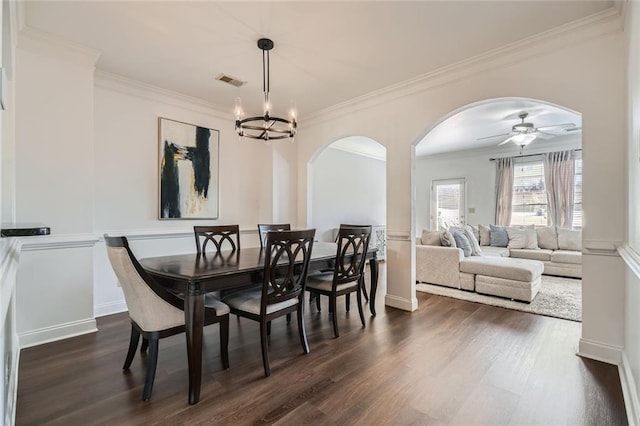 dining space featuring crown molding, dark hardwood / wood-style flooring, and ceiling fan with notable chandelier