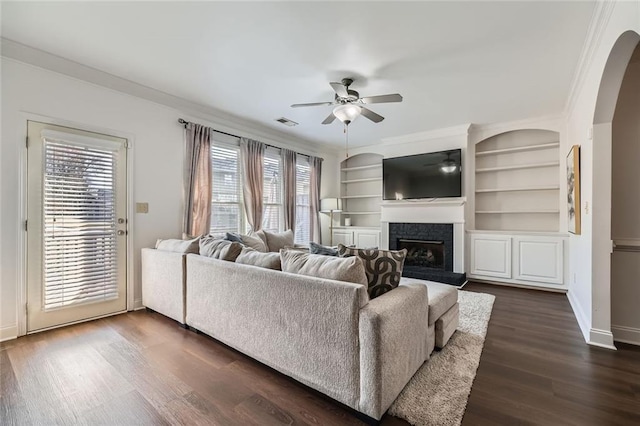 living room featuring dark hardwood / wood-style floors, a wealth of natural light, and crown molding