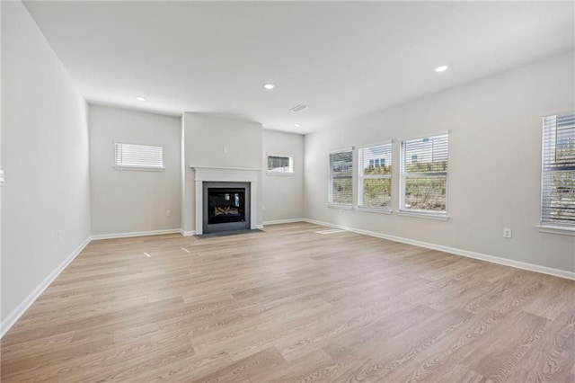 1539 High Falls Ln, Grayson, GA 30017 - unfurnished living room with plenty of natural light, light wood-style flooring, recessed lighting, and a fireplace with flush hearth