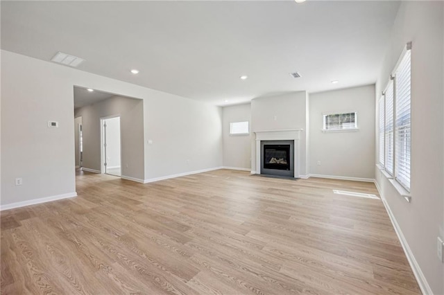 1539 High Falls Ln, Grayson, GA 30017 - unfurnished living room with healthy amount of natural light, a fireplace with flush hearth, light wood-type flooring, and recessed lighting