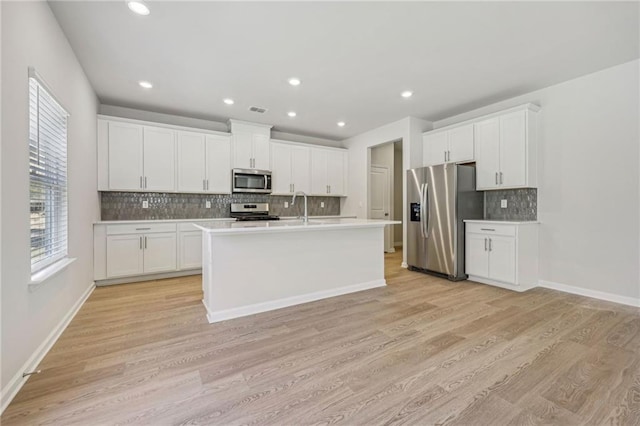 1539 High Falls Ln, Grayson, GA 30017 - kitchen featuring stainless steel appliances, backsplash, light countertops, light wood-style floors, and recessed lighting