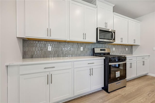 1539 High Falls Ln, Grayson, GA 30017 - kitchen with appliances with stainless steel finishes, light wood-style floors, white cabinetry, and backsplash