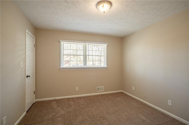 spare room with carpet and a textured ceiling