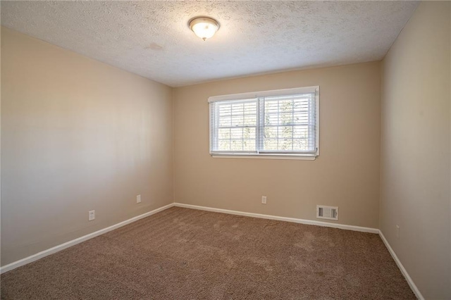 carpeted empty room with a textured ceiling
