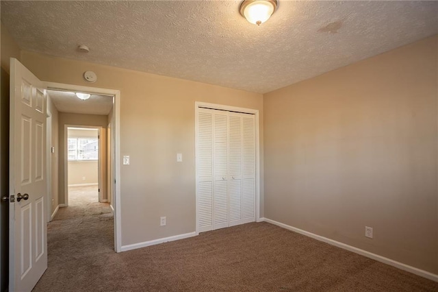 unfurnished bedroom with carpet flooring, a textured ceiling, and a closet