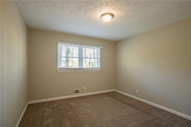 carpeted spare room with a textured ceiling