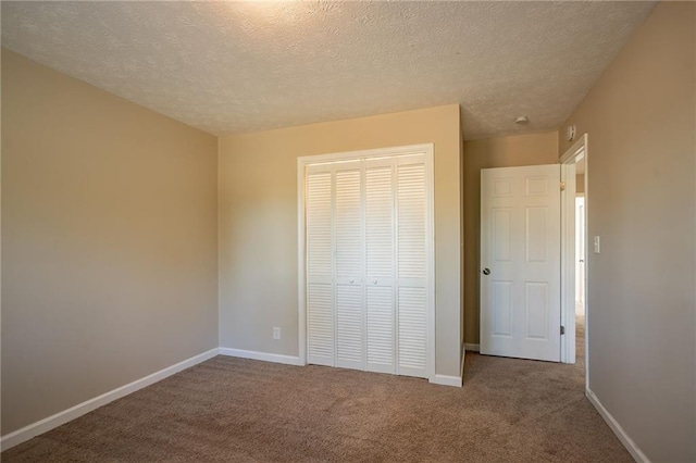 unfurnished bedroom with carpet flooring, a closet, and a textured ceiling