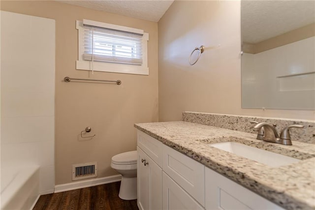 bathroom featuring hardwood / wood-style floors, vanity, a textured ceiling, and toilet