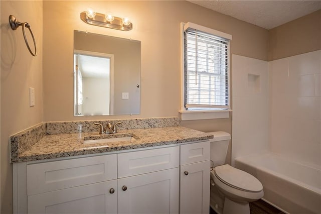 full bathroom featuring  shower combination, vanity, a textured ceiling, and toilet