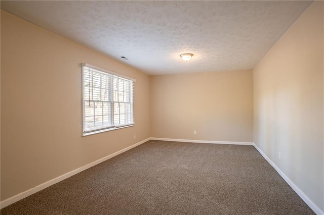 carpeted empty room featuring a textured ceiling