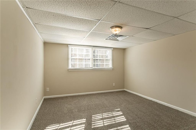 carpeted empty room featuring a paneled ceiling
