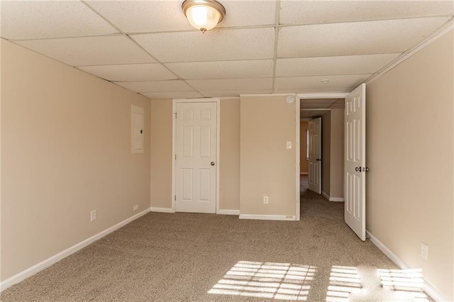 interior space with a paneled ceiling, carpet floors, and electric panel