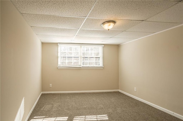 empty room featuring carpet flooring and a paneled ceiling