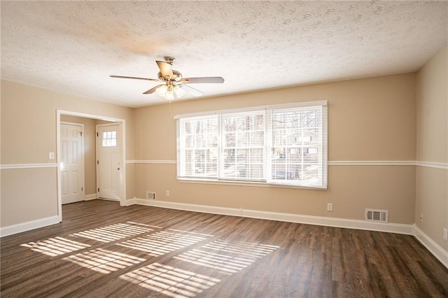 empty room featuring ceiling fan, dark hardwood / wood-style flooring, and a textured ceiling