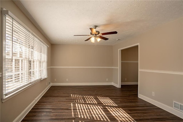 empty room with ceiling fan, dark hardwood / wood-style flooring, and a textured ceiling