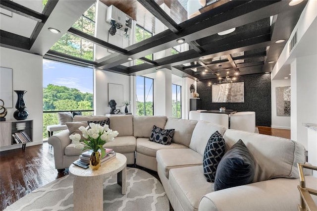 living area featuring healthy amount of natural light, wood finished floors, beamed ceiling, baseboards, and recessed lighting
