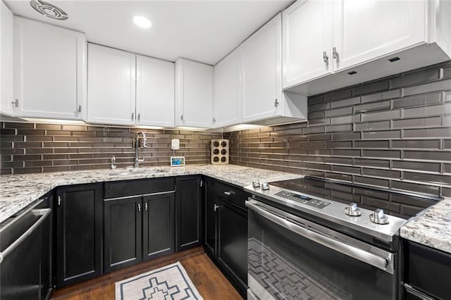 kitchen featuring stainless steel appliances, a sink, dark cabinetry, white cabinets, and recessed lighting