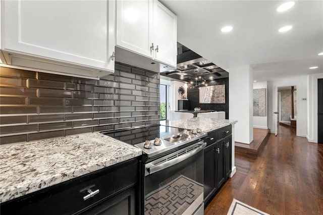 kitchen featuring stainless steel electric range, tasteful backsplash, white cabinets, dark cabinets, and light stone counters