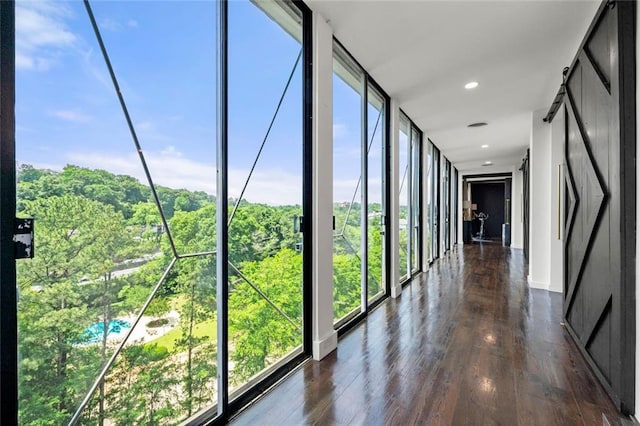 hall with dark wood-style floors, recessed lighting, and baseboards