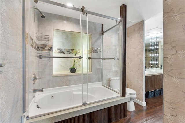 bathroom with toilet, bath / shower combo with glass door, vanity, and wood finished floors