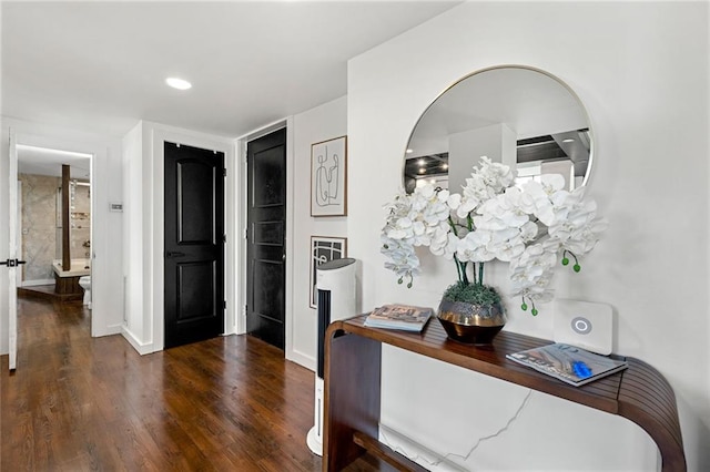 corridor with wood finished floors and baseboards