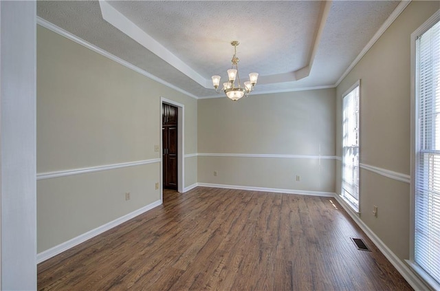 unfurnished room featuring a textured ceiling, visible vents, baseboards, dark wood-style floors, and a tray ceiling