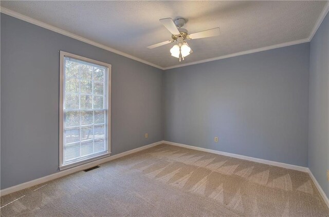 empty room with baseboards, visible vents, ornamental molding, and light colored carpet