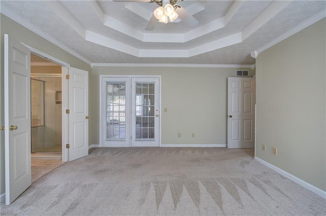 spare room with carpet floors, french doors, a raised ceiling, visible vents, and baseboards