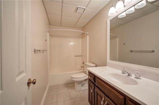 bathroom featuring a drop ceiling, bathing tub / shower combination, toilet, tile patterned floors, and vanity