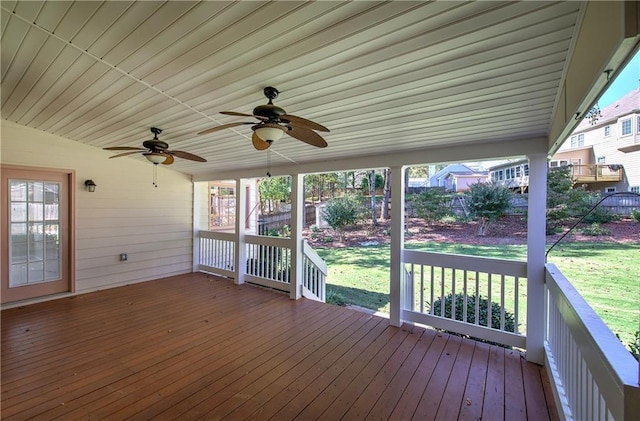 wooden terrace featuring ceiling fan and a lawn