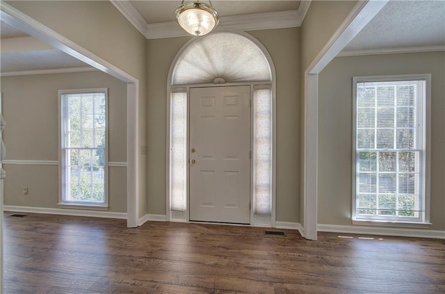 foyer entrance featuring crown molding, baseboards, and wood finished floors