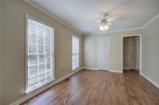 interior space with baseboards, ceiling fan, wood finished floors, crown molding, and a textured ceiling