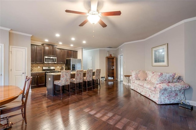 living room featuring ceiling fan, ornamental molding, and dark hardwood / wood-style flooring