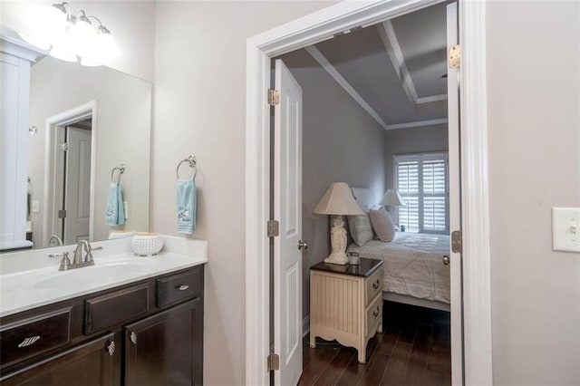 bathroom with vanity, crown molding, and hardwood / wood-style flooring