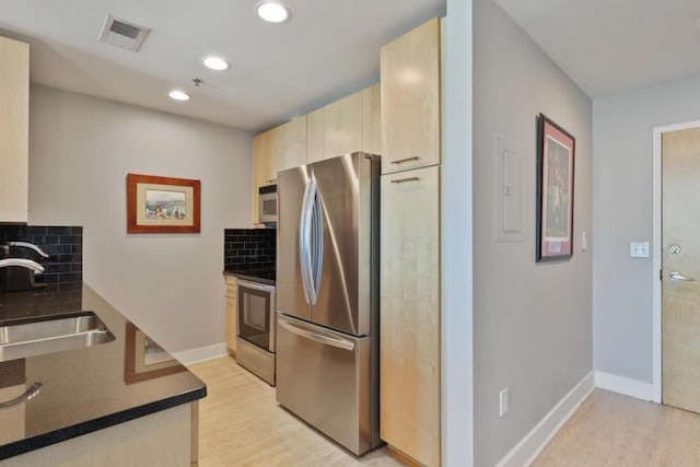 kitchen featuring light hardwood / wood-style floors, sink, appliances with stainless steel finishes, and tasteful backsplash