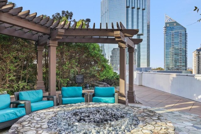 view of patio / terrace with a pergola and an outdoor living space with a fire pit