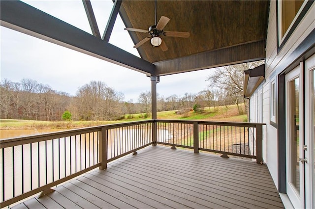 deck with a water view and ceiling fan