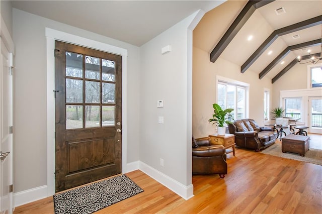 entrance foyer with high vaulted ceiling, a notable chandelier, beam ceiling, and light hardwood / wood-style flooring