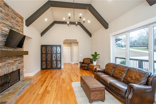 living room with high vaulted ceiling, a fireplace, a notable chandelier, beam ceiling, and light hardwood / wood-style flooring