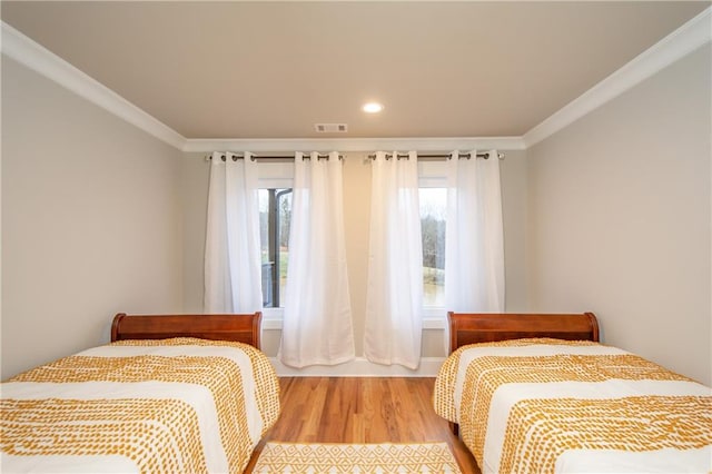 bedroom with ornamental molding and light hardwood / wood-style flooring