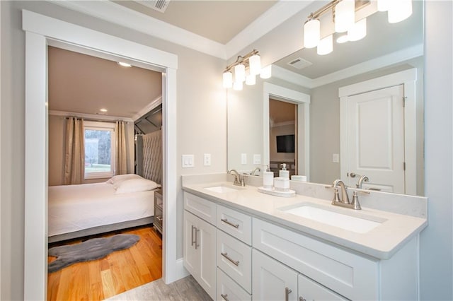 bathroom with hardwood / wood-style flooring, vanity, and crown molding