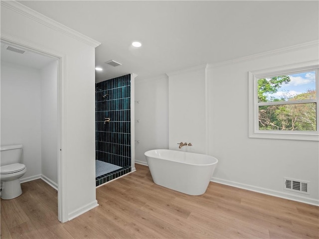 bathroom with visible vents, toilet, a shower stall, and wood finished floors