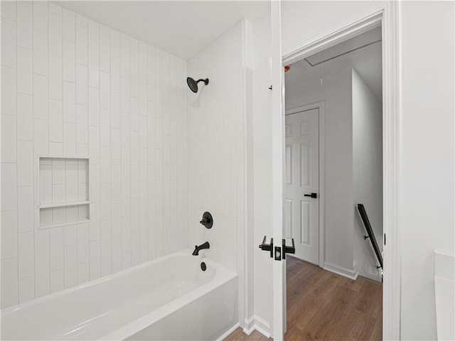 full bathroom featuring baseboards, wood finished floors, and tub / shower combination