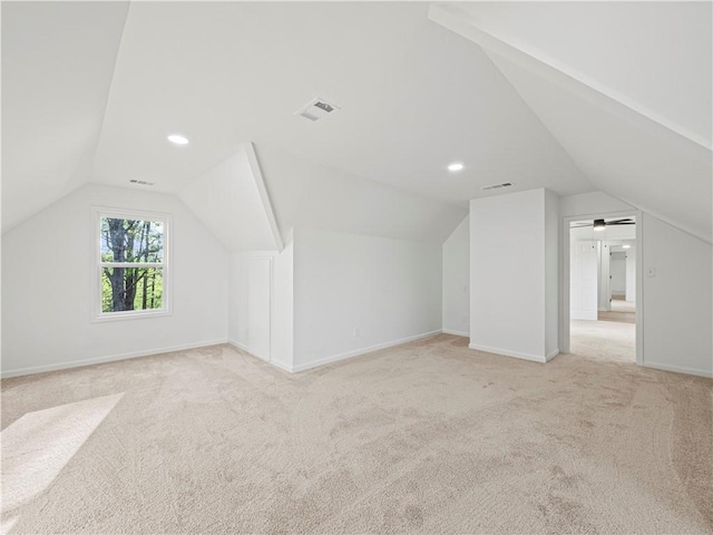 additional living space with visible vents, baseboards, and vaulted ceiling